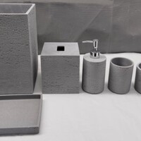 Set de baño de resina, apariencia de piedra. Incluye: bote de basura, caja de pañuelos, dispensador de jabón, contenedor para cepillo, charola, contenedor y una jabonera.